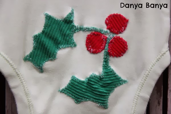 Christmas holly appliquéd on the bottom of a baby onesie